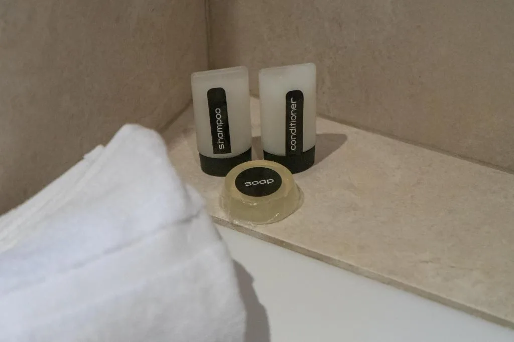 Bathroom amenities with shampoo, conditioner, and soap on vanity
