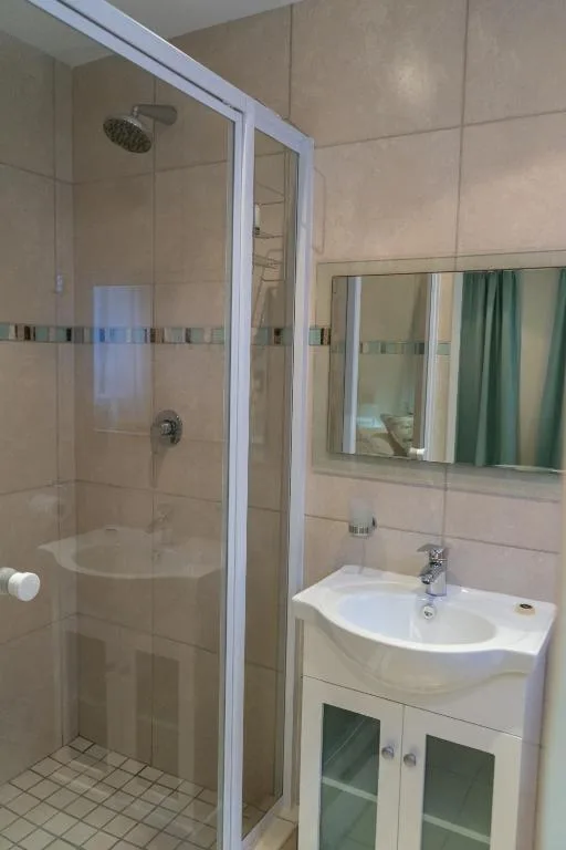 Modern bathroom with curved glass shower enclosure and white vanity sink