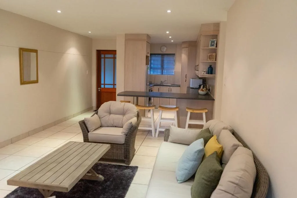 Open-plan lounge with comfortable seating and kitchen area visible