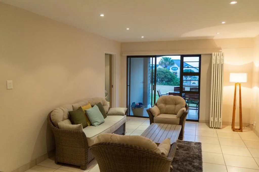 Spacious living room with woven furniture and sliding doors to deck area