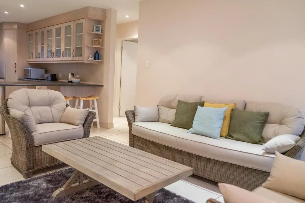 Contemporary lounge with wicker furniture, colorful cushions, and kitchenette