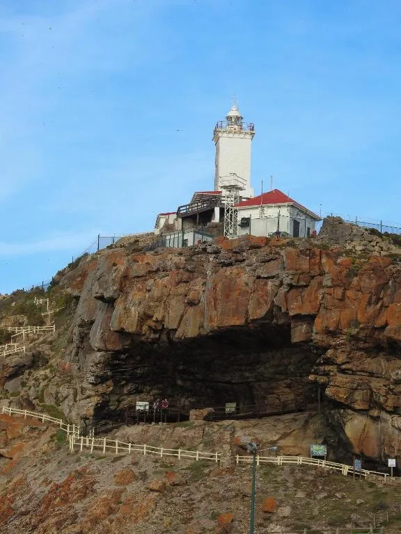 Iconic lighthouse perched on rocky coastal cliff with scenic ocean views