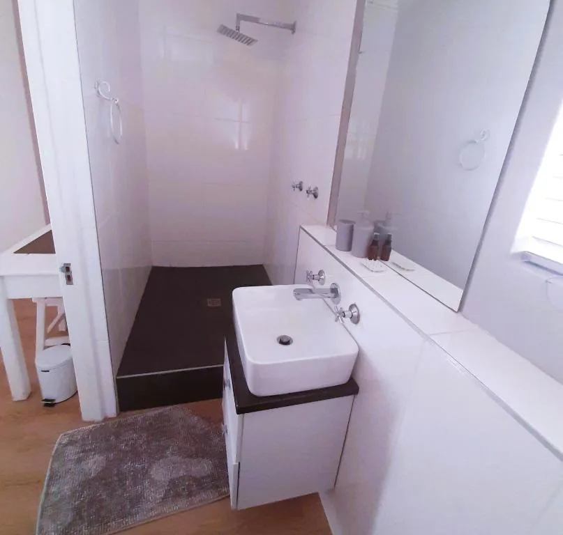 Modern bathroom with white vanity sink and enclosed shower cubicle