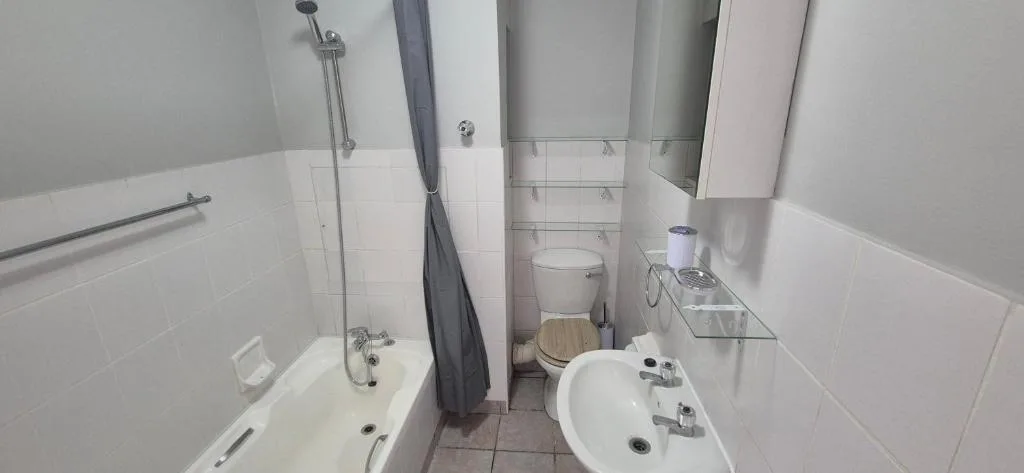 Modern bathroom with bathtub, shower, toilet, and double vanity sink