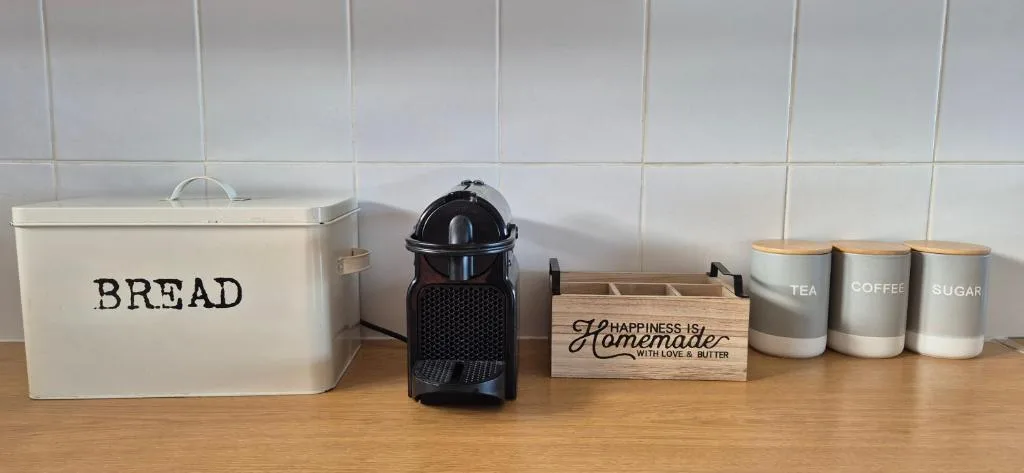Kitchen counter with bread bin, coffee machine, and storage containers