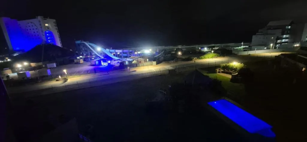 Night view of Mossel Bay beachfront with illuminated promenade and attractions