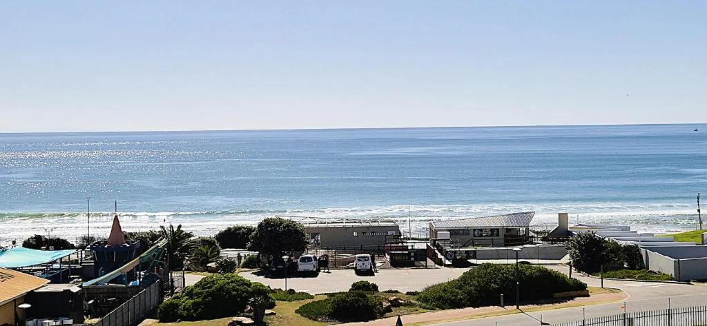 Panoramic ocean and beach view with coastal development and clear blue sky