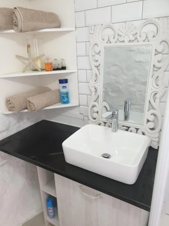 Stylish bathroom vanity with white vessel sink and decorative mirror