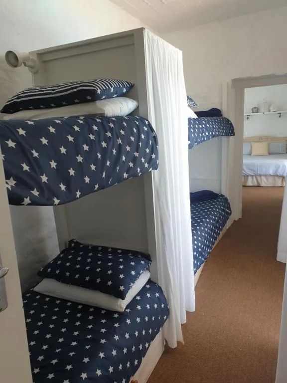 Bedroom with white bunk beds dressed in navy star-patterned bedding