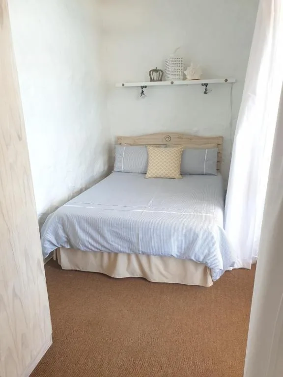 Cozy bedroom alcove with neatly made bed and decorative pillows