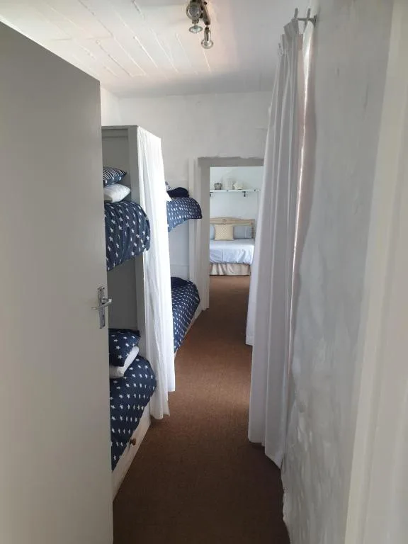 Bright bedroom with bunk beds and white curtain dividers for privacy