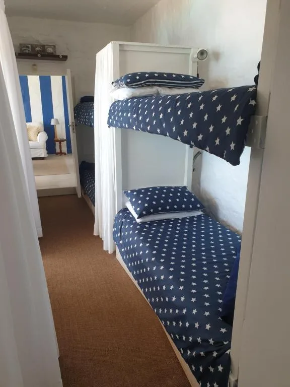 Compact bedroom with bunk beds dressed in navy star-patterned bedding