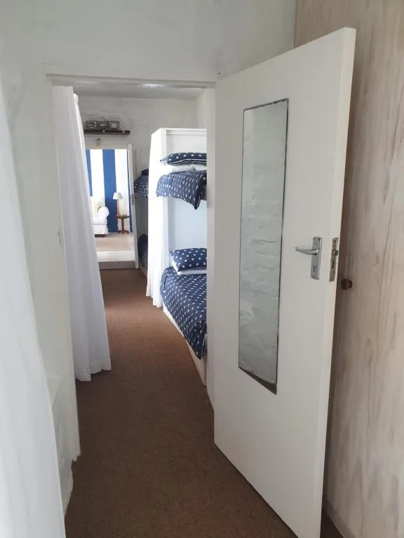 Bedroom with twin beds featuring blue patterned bedding and white walls