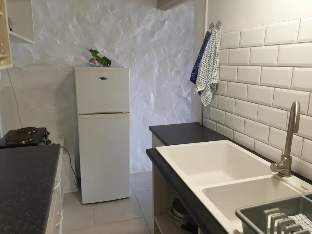 Modern kitchen with white refrigerator, subway tile backsplash, and sink area