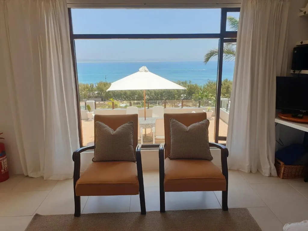 Modern lounge with brown leather chairs overlooking ocean and deck