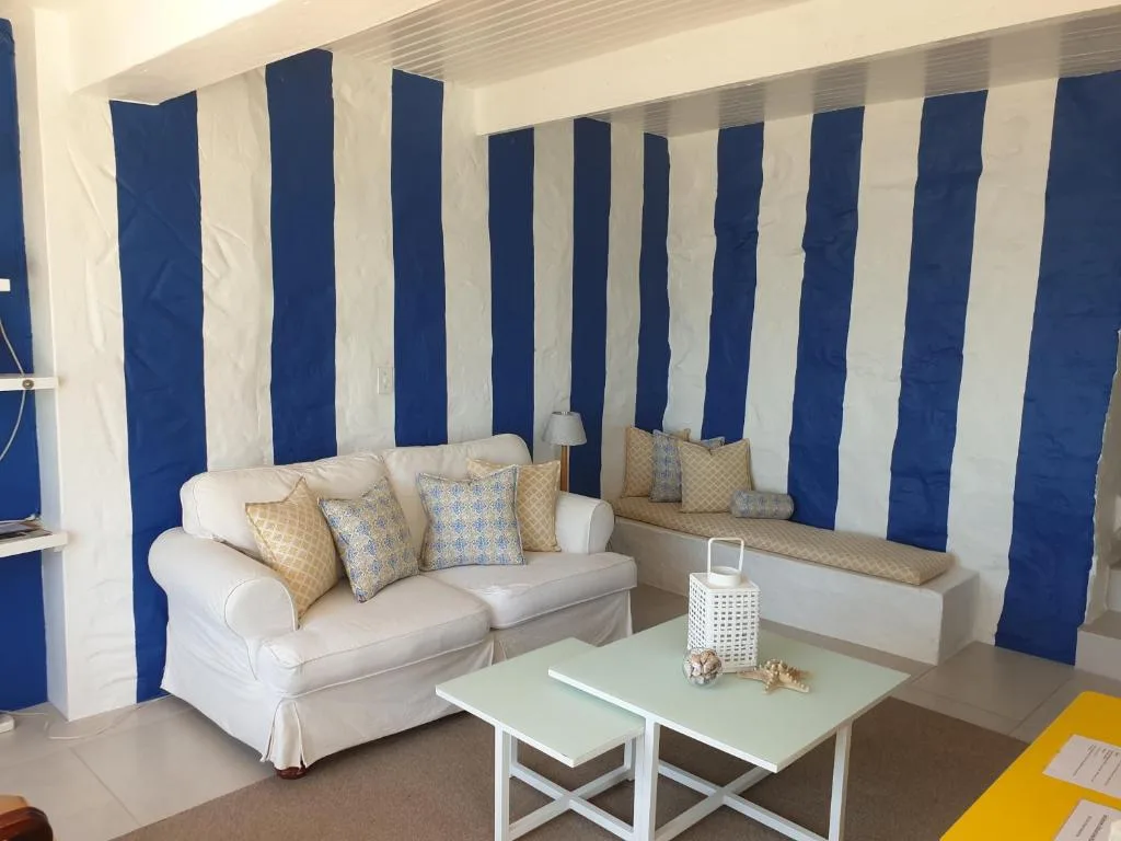 Bright lounge with blue striped accent wall, comfortable sofa, and coffee tables