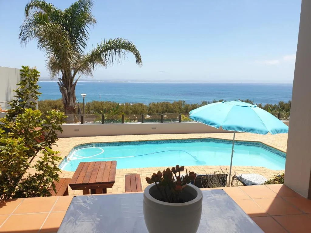 Ocean and coastline vista from property deck with pool below