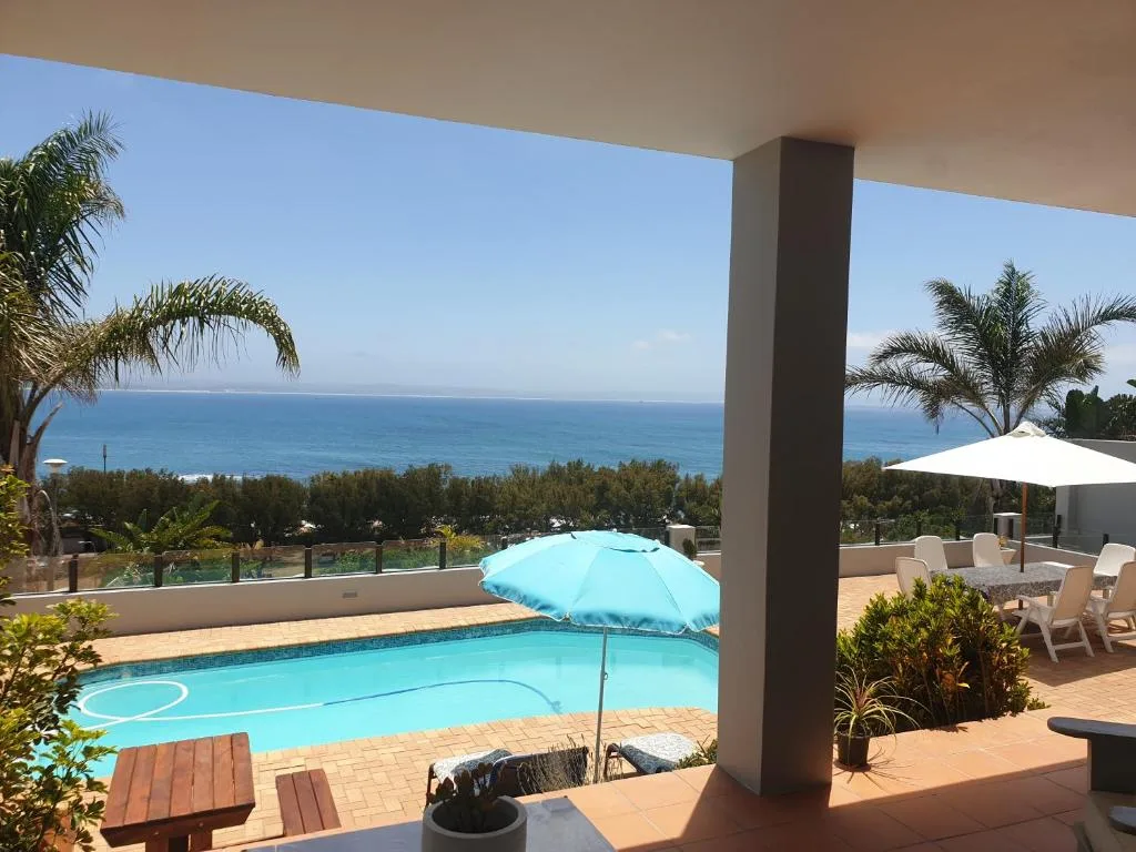 Ocean view from covered deck with pool and coastal landscape beyond