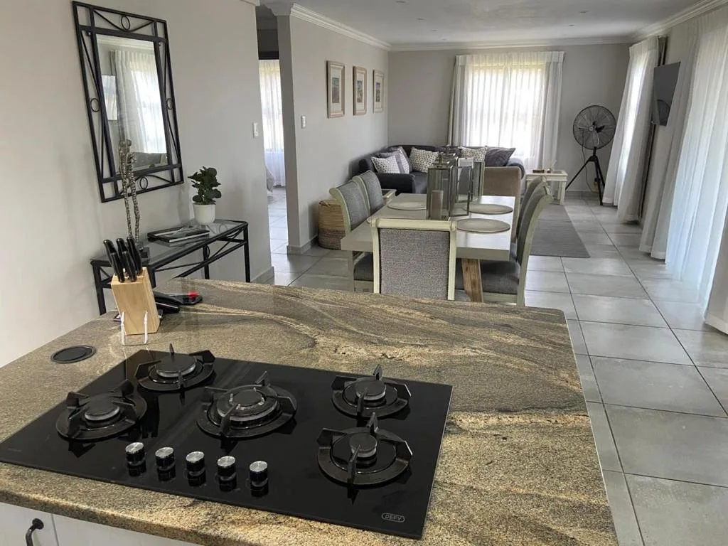 Modern kitchen with gas cooktop, granite countertop, open-plan lounge and dining area