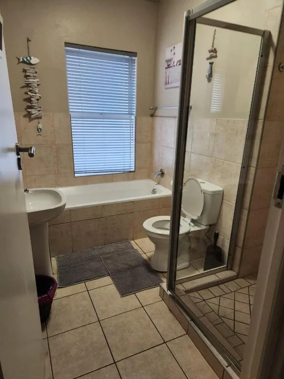 Bathroom with bathtub, shower enclosure, toilet, and large window