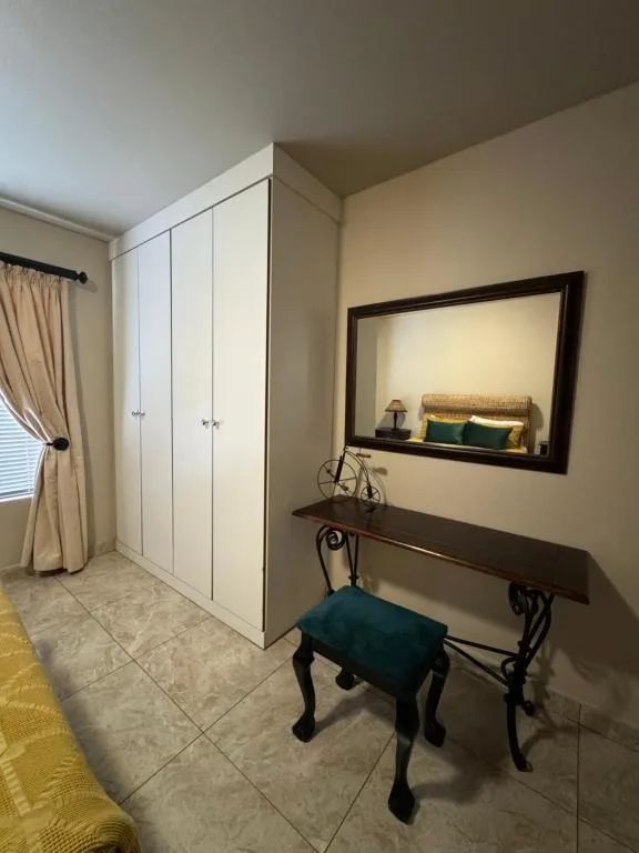 Spacious bedroom with white built-in wardrobe, vanity desk, and modern furnishings