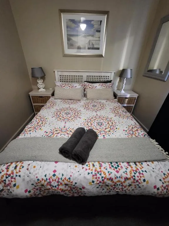 Cozy bedroom with colorful patterned bedding and twin bedside lamps