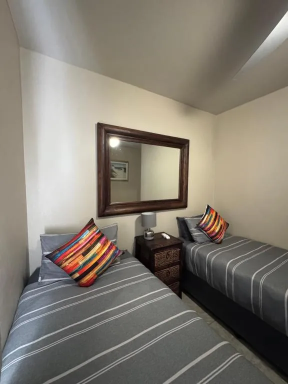 Twin bedroom with striped bedding and colorful decorative pillows
