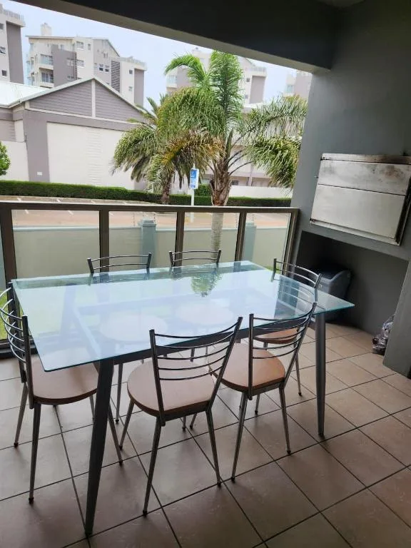 Modern outdoor dining table with chairs on covered patio area
