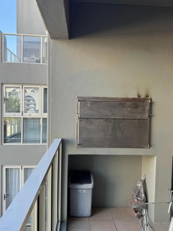 Apartment balcony with white railing and outdoor utility storage