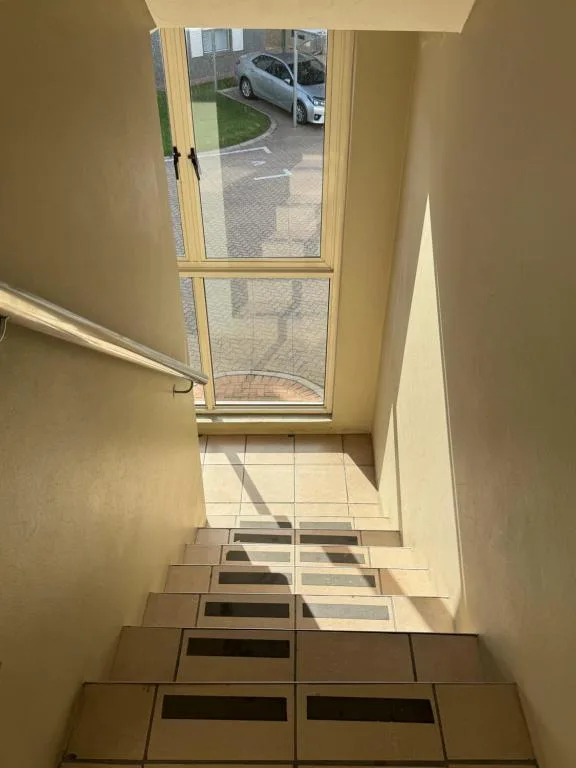 Entry hallway with stairs leading to driveway and parked car