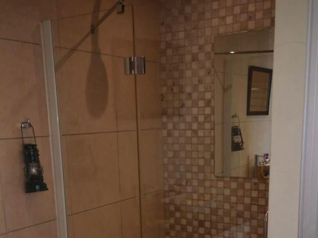 Modern walk-in shower with glass enclosure and tiled walls