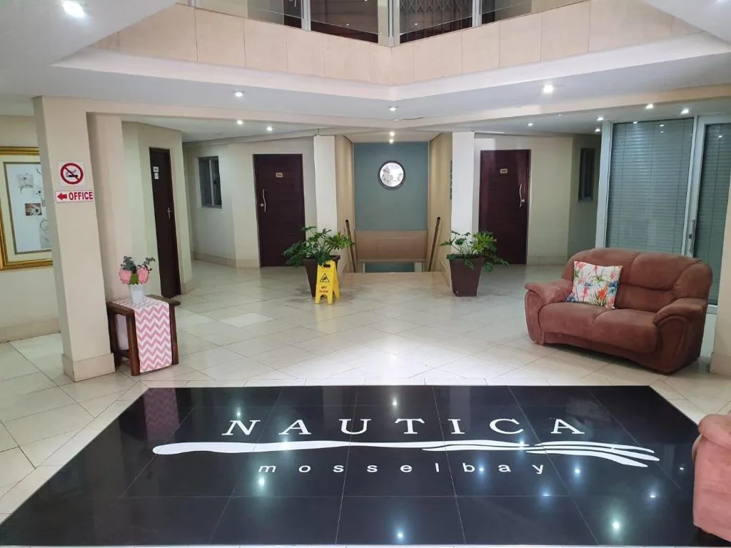 Modern apartment lobby entrance with branded floor mat and seating area