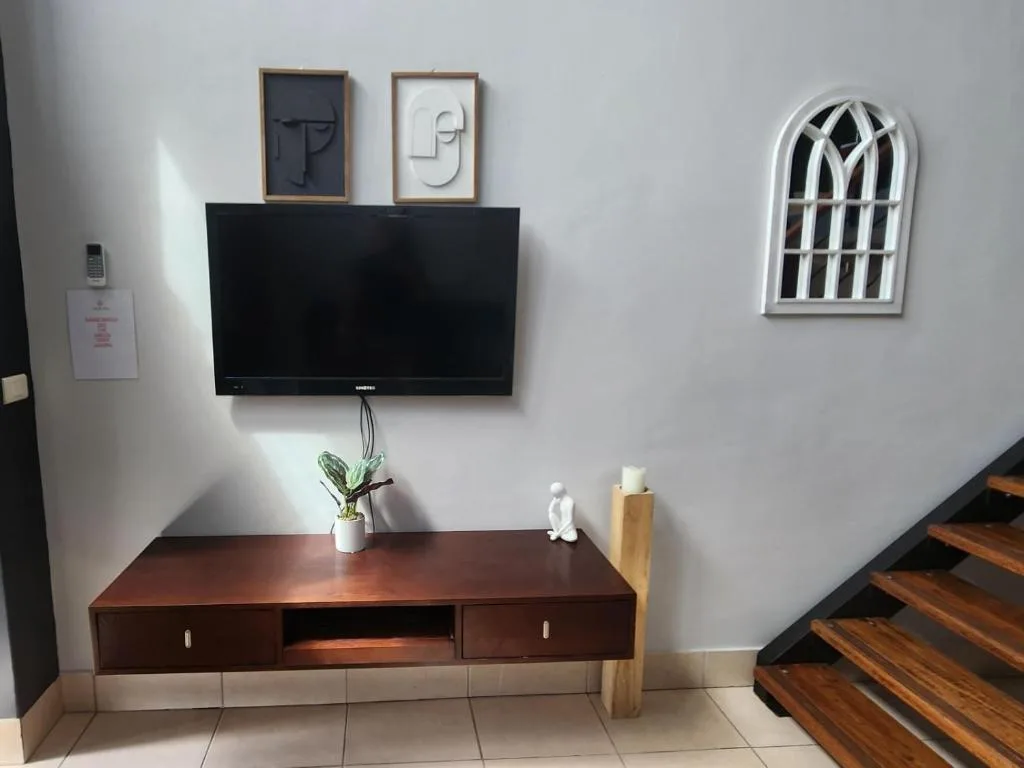 Modern lounge area with wall-mounted TV and wooden entertainment unit