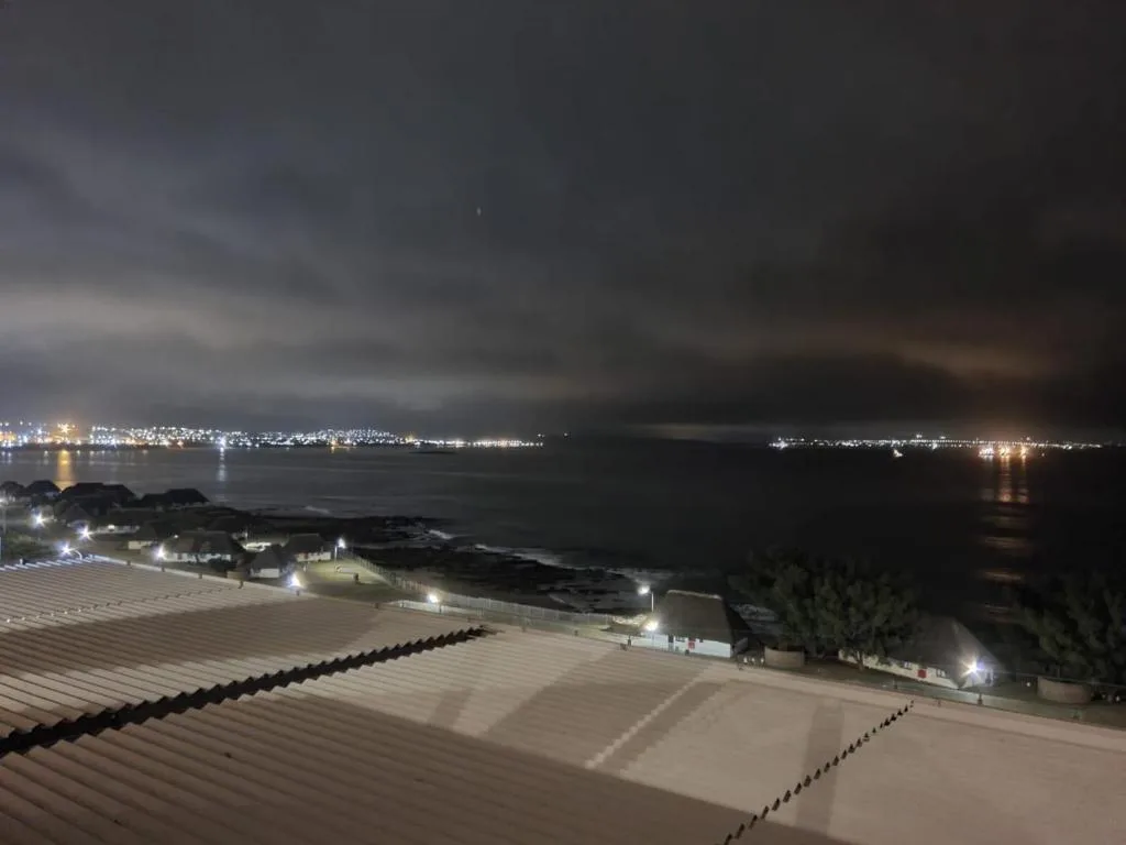 Night view of Mossel Bay coastline with town lights reflecting on water