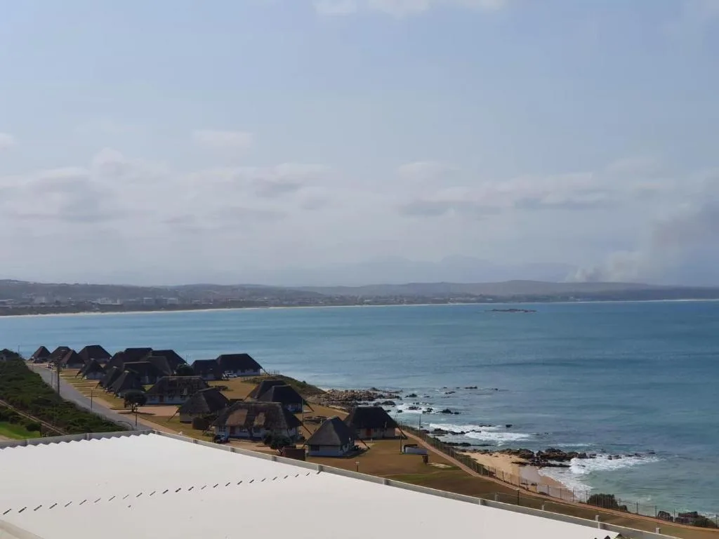 Coastal view of beach and mountains across turquoise ocean waters