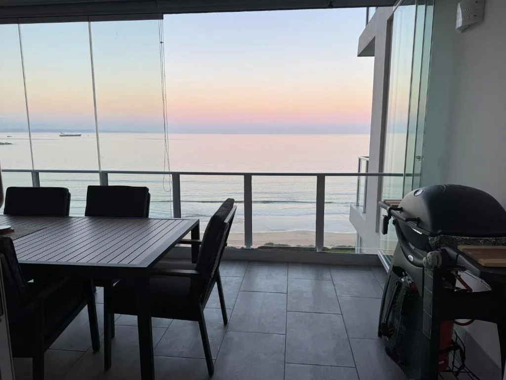 Oceanfront deck with dining table and sea view at sunset