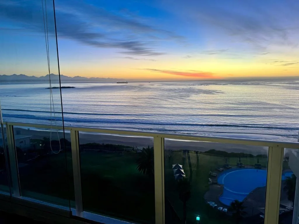 Panoramic sunset ocean view from beachfront deck with mountains
