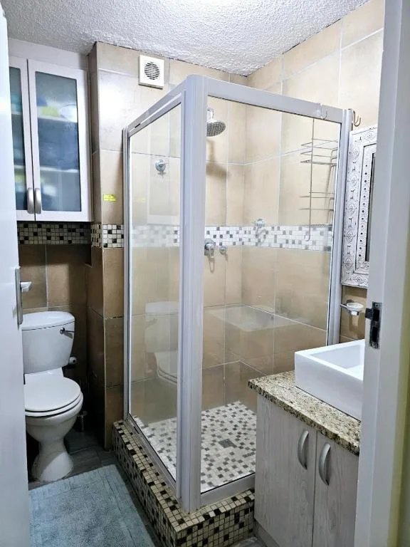 Modern bathroom with glass shower enclosure and white vanity sink