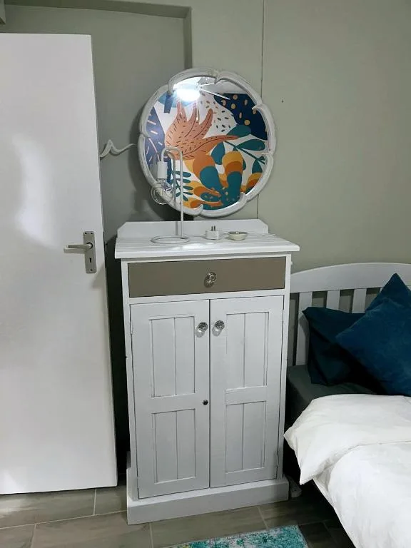 Bedroom with white cabinet, decorative fan, and blue accent pillow on bed