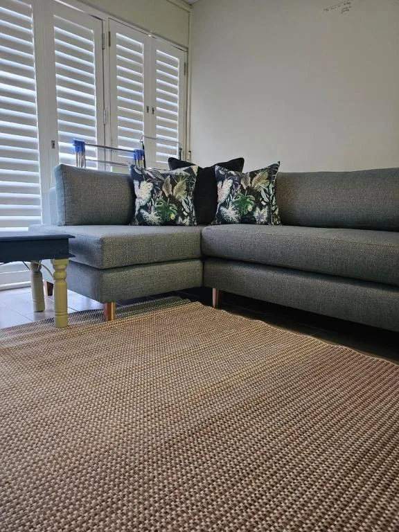 Modern gray corner sofa with patterned cushions in bright living room