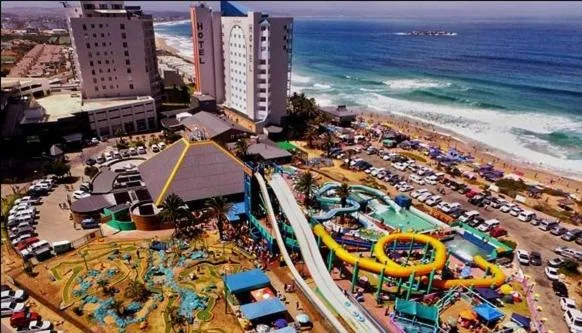 Aerial view of beachfront property with ocean, beach, and coastal town