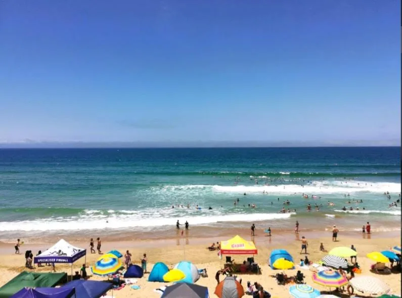Scenic beach view with turquoise waters, white sand, and colorful beach umbrellas