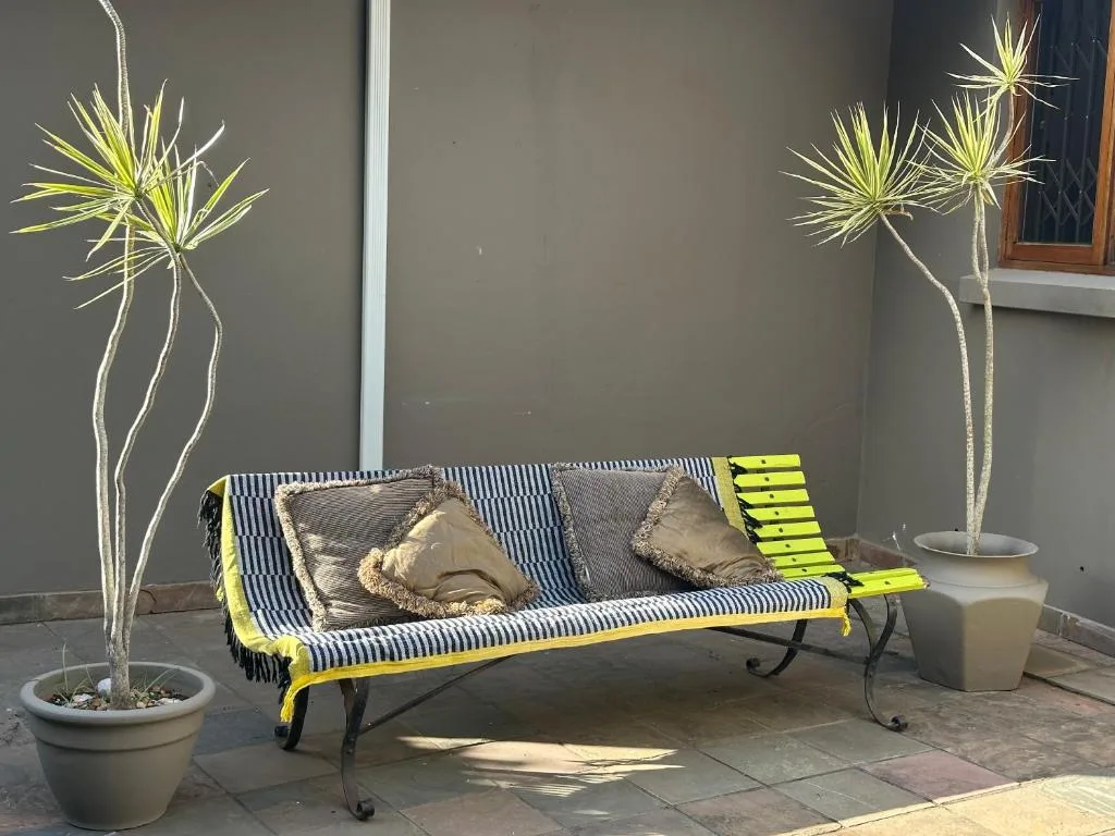 Striped outdoor seating area with potted plants and decorative cushions