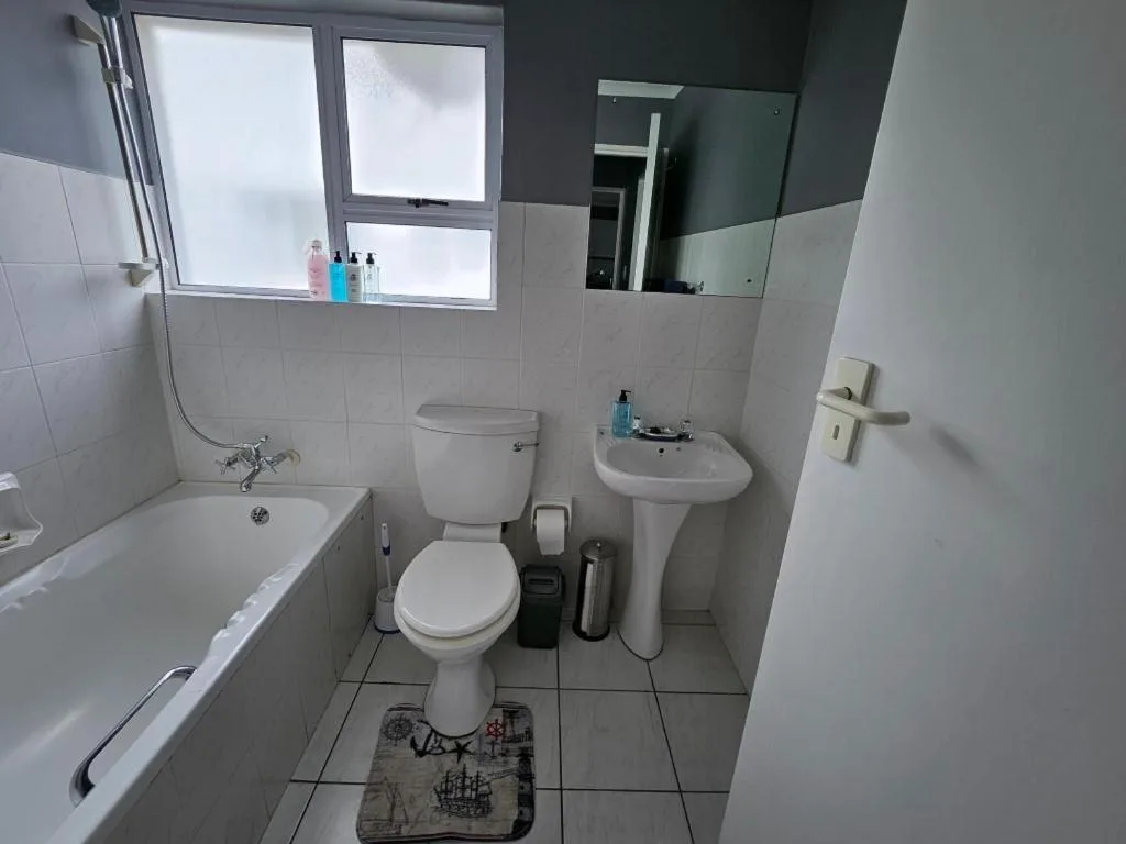 Clean bathroom with bathtub, toilet, sink and mirror