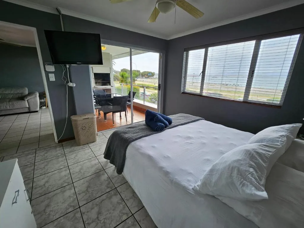 Spacious bedroom with queen bed, TV, and scenic views through large windows