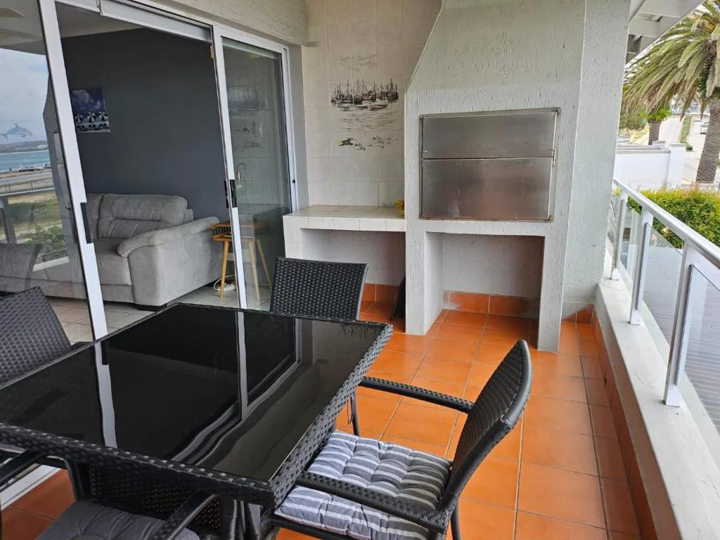 Outdoor terrace with dining table, chairs, and ocean view access doors