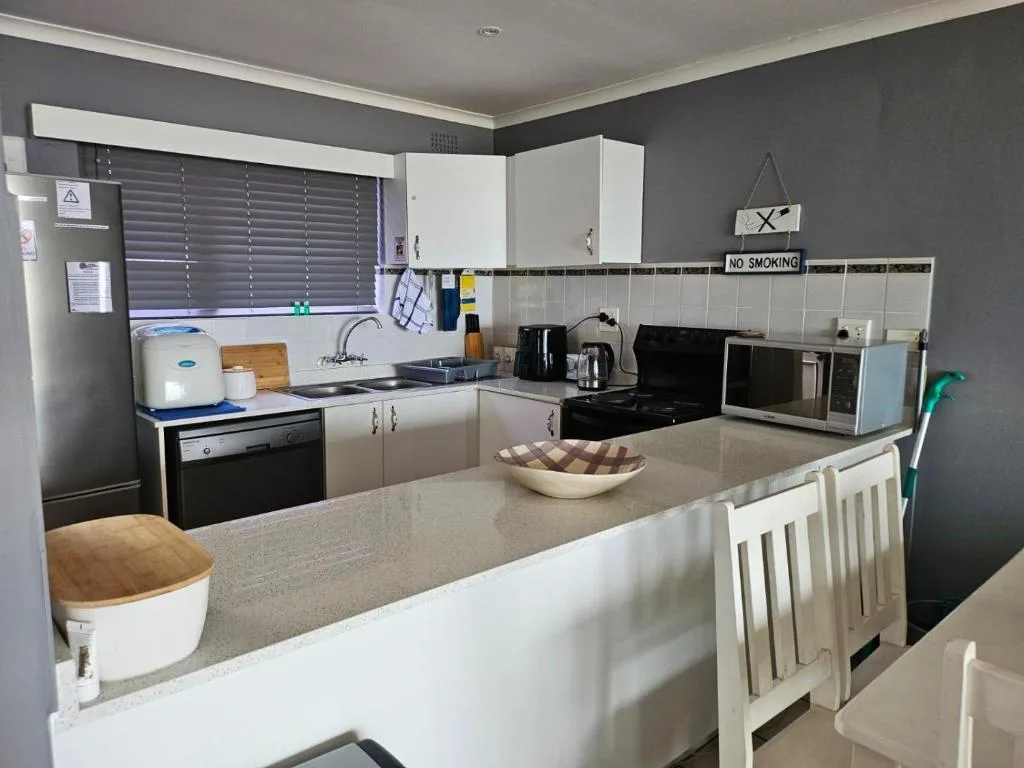 Modern kitchen with white cabinetry, stainless steel appliances, and gray walls