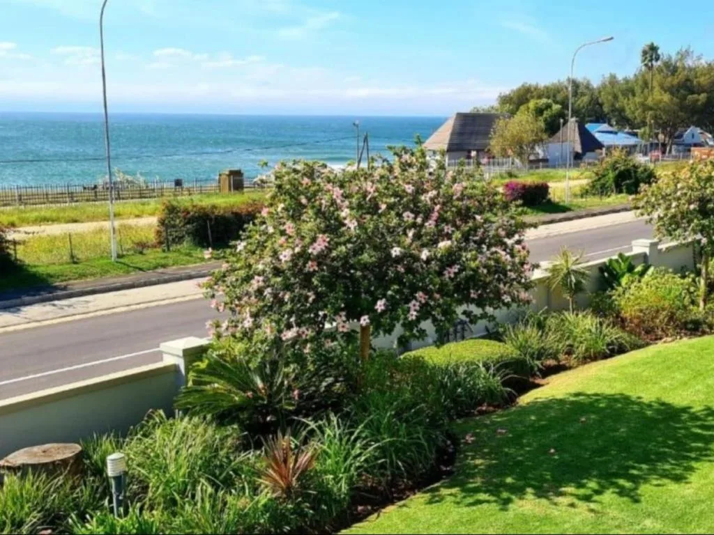 Ocean vista with manicured garden and coastal property in background