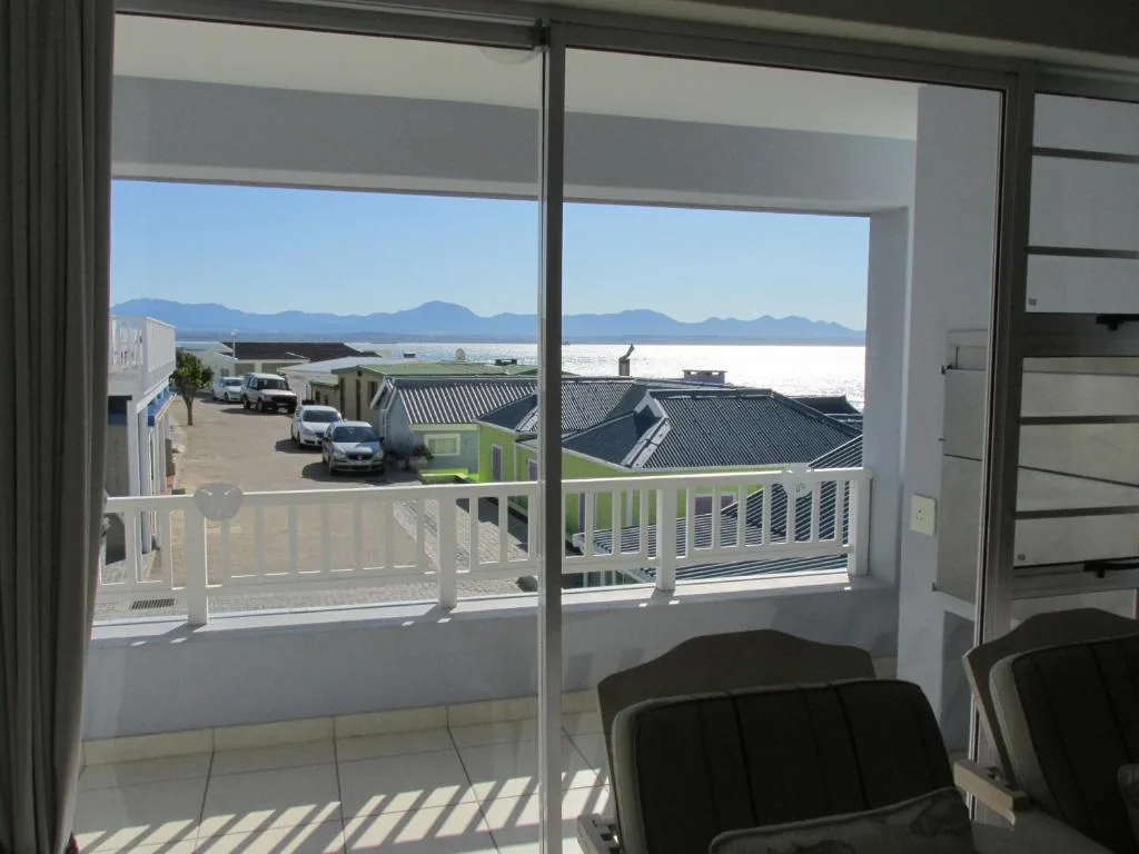 Scenic ocean and mountain vista from balcony with white railings