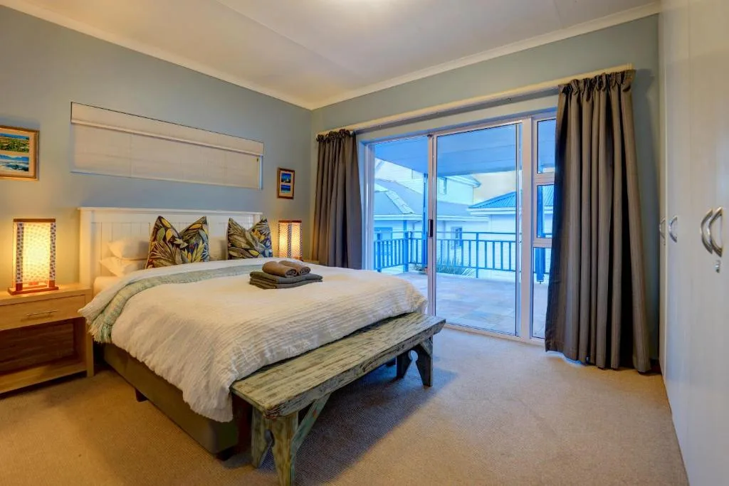 Spacious bedroom with ocean view deck access and modern furnishings